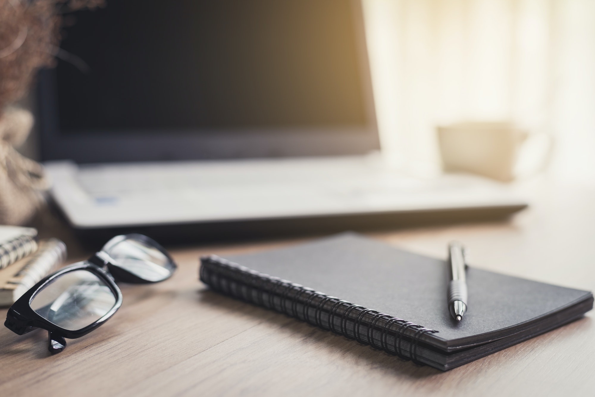 Notebook and laptop in home office with soft light